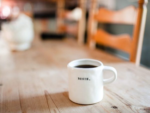 white-ceramic-mug-on-table-with-the-word-begin-on-it