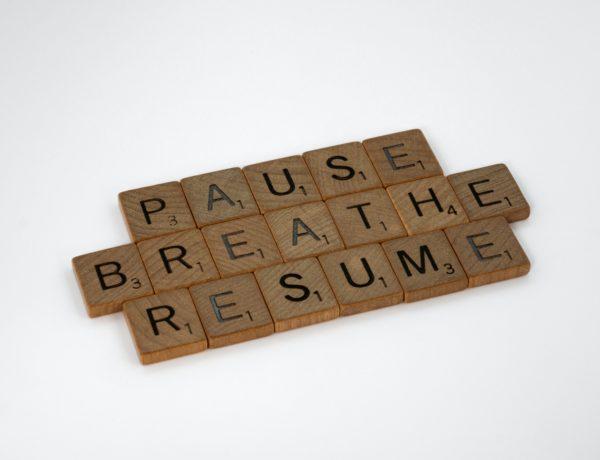 wooden blocks on white background spelling pause breathe resume